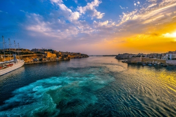 a view of teh sunsetting over the Mediterranean sea and seaside town 