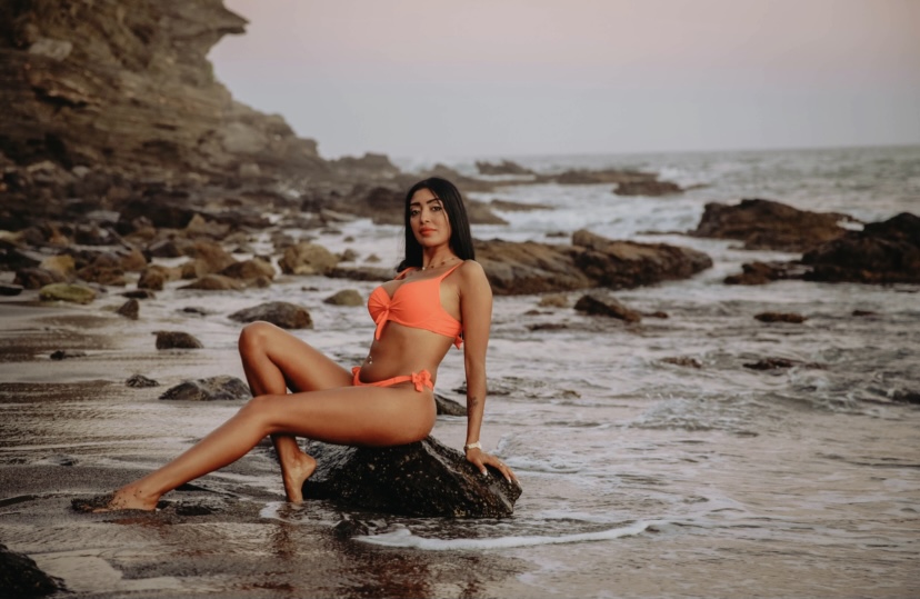 Maya looking sexy on the beach wearing an orange bikini
